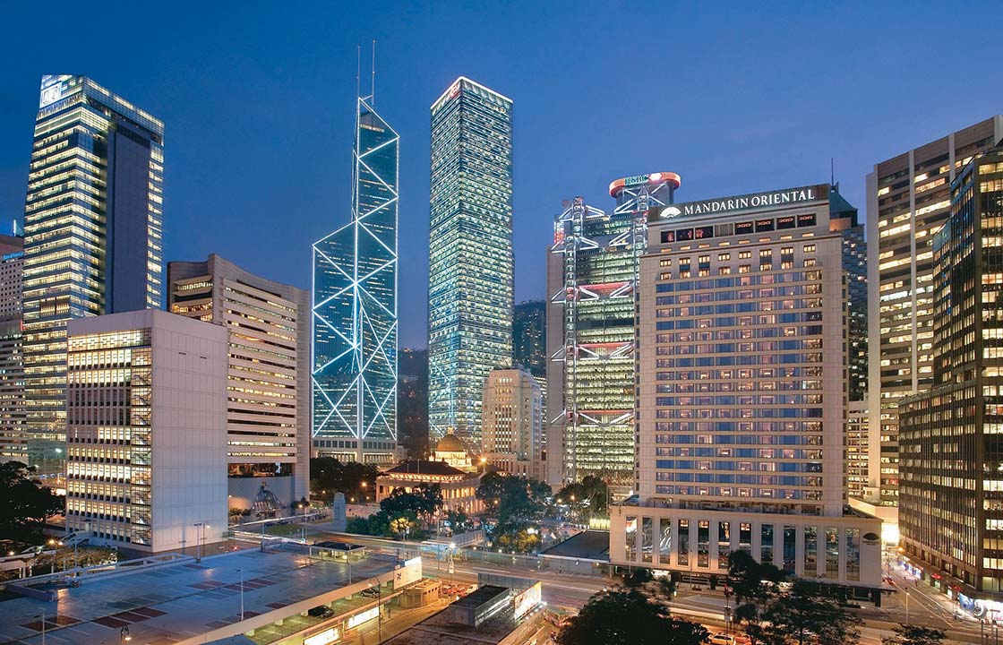 The Mandarin Oriental Hotel Hong Kong at night surrounded by other hotels and busy streets